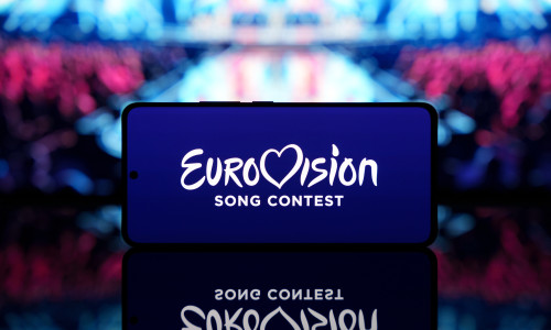 Smartphone,Displaying,Eurovision,Song,Contest,Logo,With,A,Blurred,Stage