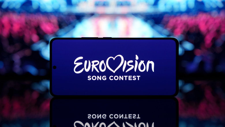 Smartphone,Displaying,Eurovision,Song,Contest,Logo,With,A,Blurred,Stage