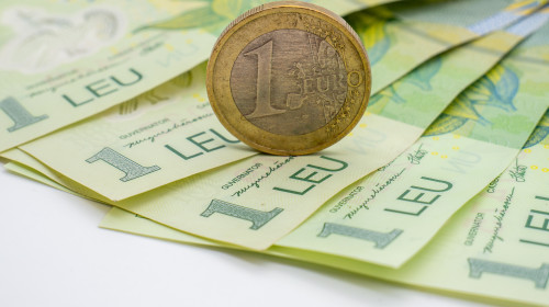 A,One,Euro,Coin,Put,On,Romanian,Banknotes,Of,One