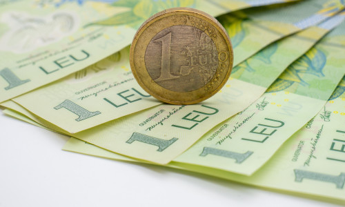 A,One,Euro,Coin,Put,On,Romanian,Banknotes,Of,One