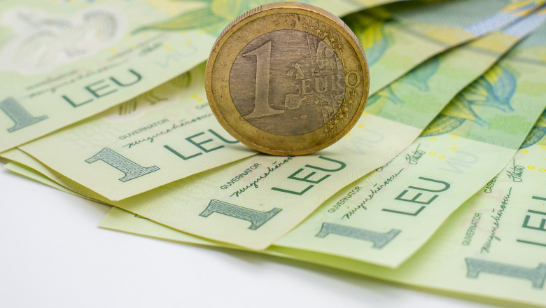 A,One,Euro,Coin,Put,On,Romanian,Banknotes,Of,One