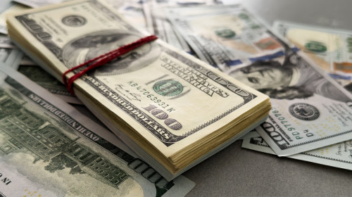 Pile,Of,Us,100,Dollar,Banknotes,On,Dollars,Background