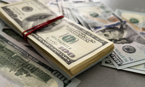 Pile,Of,Us,100,Dollar,Banknotes,On,Dollars,Background