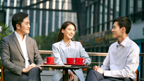 Three,Asian,Corporate,Businesspeople,Discussing,Business,Outdoors,In,Coffee,Shot