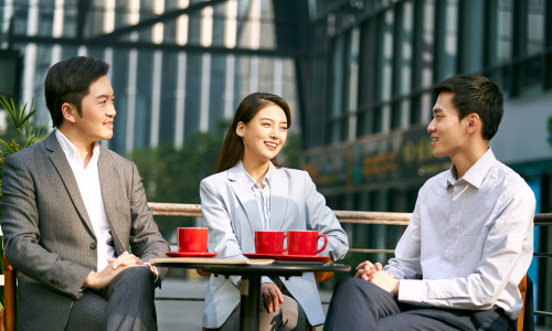 Three,Asian,Corporate,Businesspeople,Discussing,Business,Outdoors,In,Coffee,Shot