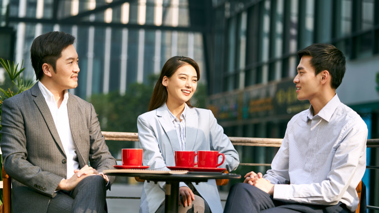 Three,Asian,Corporate,Businesspeople,Discussing,Business,Outdoors,In,Coffee,Shot