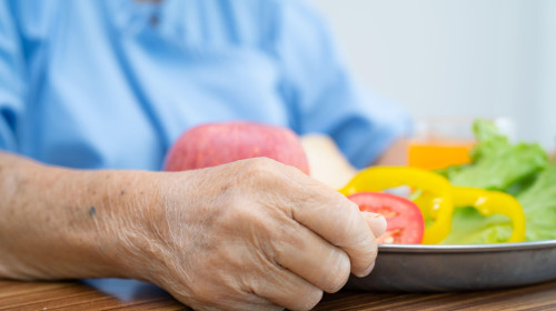 Asian senior or elderly old lady woman patient eating breakfast vegetable healthy food with hope and happy while sitting and hungry on bed in hospital