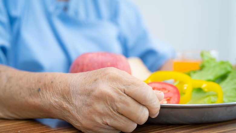 Asian senior or elderly old lady woman patient eating breakfast vegetable healthy food with hope and happy while sitting and hungry on bed in hospital