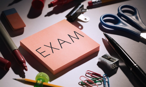 Exam against students table with school supplies