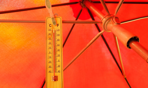 Global Heat wave in the summer, parasol and and thermometer displaying high temperature, free copy space