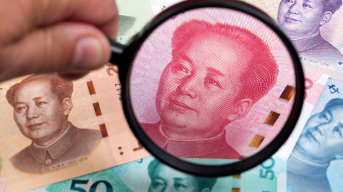 Chinese Yuans in a magnifying glass a business background
