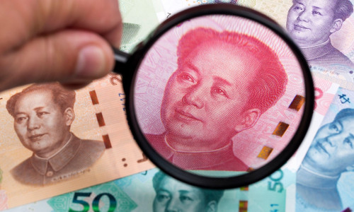 Chinese Yuans in a magnifying glass a business background
