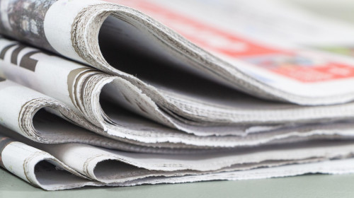 Pile of folded french newspapers on a table