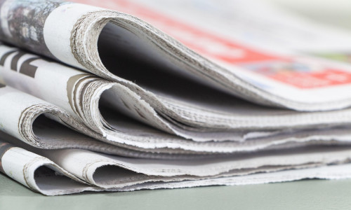 Pile of folded french newspapers on a table