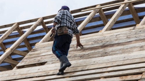 A man works on the construction of a wooden roof in the Maramures region, Romania
