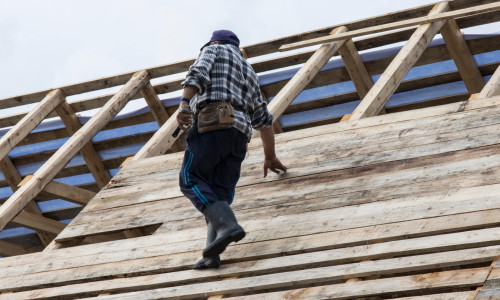 A man works on the construction of a wooden roof in the Maramures region, Romania