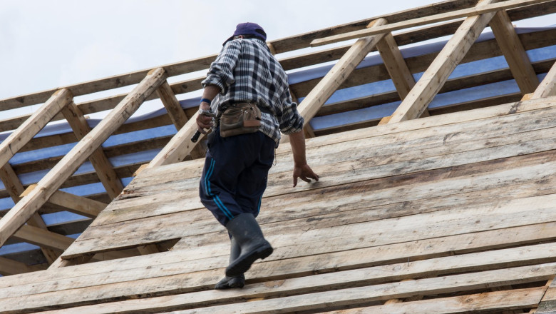 A man works on the construction of a wooden roof in the Maramures region, Romania