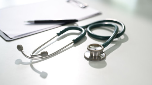Stethoscope on a white desk with clipboard symbolizing diagnostics, and healthcare concept