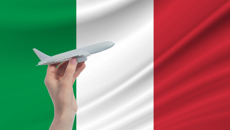 Airplane in hand with national flag of Italy Travel to Italy.