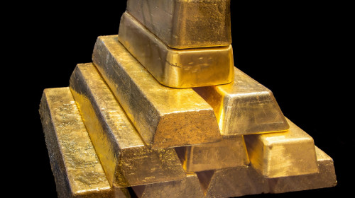 Stack of Shiny 24K real Gold Bullion Bars on Black Background. Wealth, Investment, Finance and Precious Metal Concept