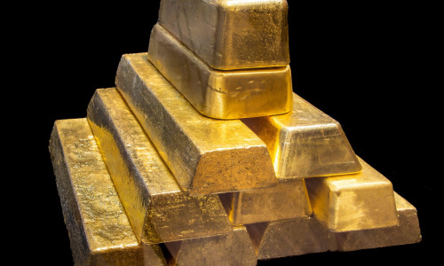 Stack of Shiny 24K real Gold Bullion Bars on Black Background. Wealth, Investment, Finance and Precious Metal Concept