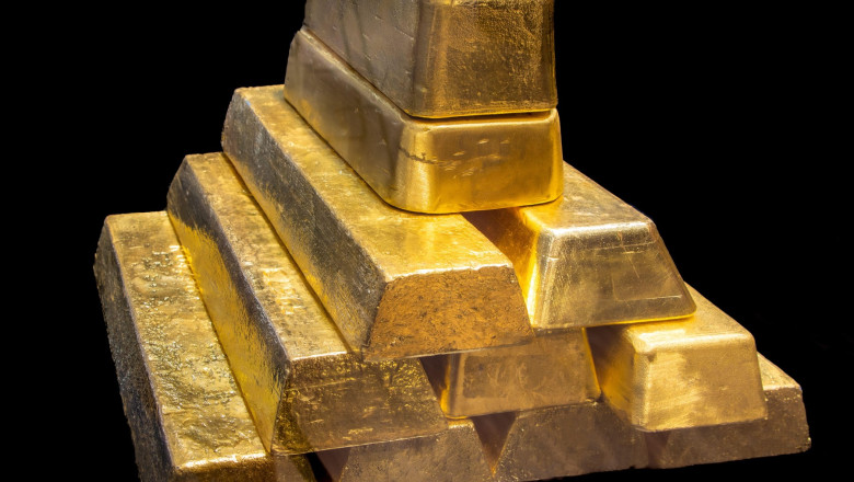 Stack of Shiny 24K real Gold Bullion Bars on Black Background. Wealth, Investment, Finance and Precious Metal Concept