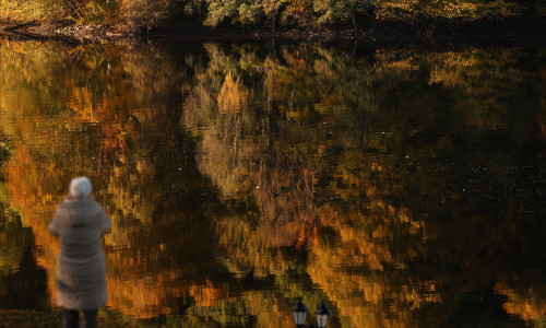 Autumnal foliage is reflected on Loch Faskally, in Pitlochry