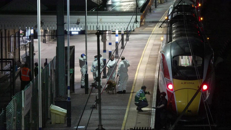 Grab taken from PA video of forensic investigators on the platform at Huntingdon station in Cambridgeshire, after a number of people were stabbed on a train. Two people have been arrested after British Transport Police were called to the incident on a tra
