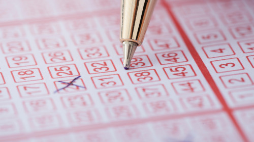 Closeup of pen marking numbers on lottery ticket