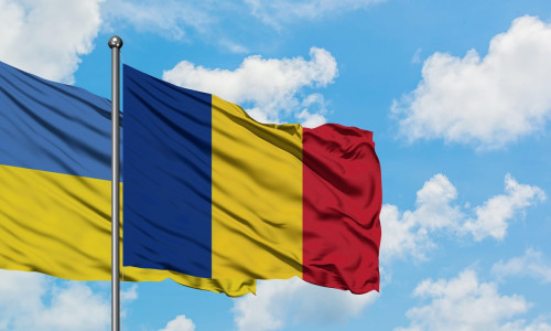 Ukraine and Romania flag waving in the wind against white cloudy blue sky together. Diplomacy concept, international relations.
