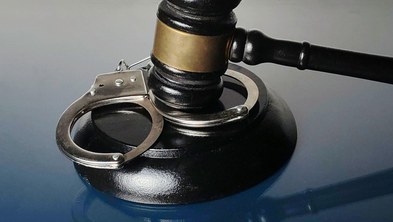 Handcuffs Resting on Gavel Base with Judge's Mallet Symbolizing Crime and Law Enforcement