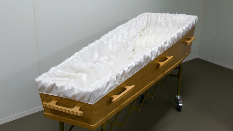 An empty coffin with white sheet in a morgue