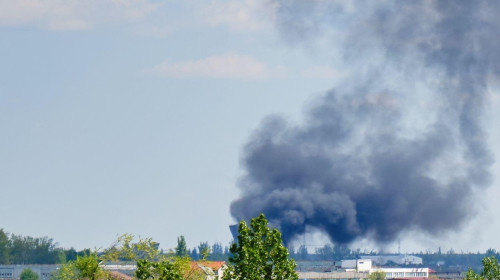 Black heavy smoke cloud near apartment building in residential area of Bucharest, Romania, on a sunny Spring day.