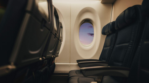 Soft light falls across empty airplane seats at the window.