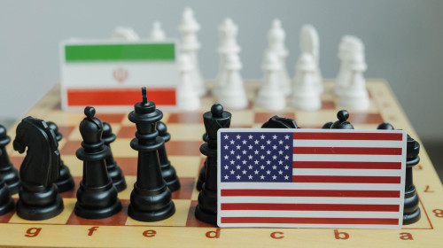 Flag of USA and a Iranian flag on chessboard. Conflict between those two countries.