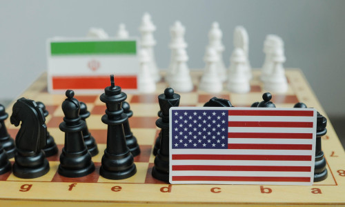 Flag of USA and a Iranian flag on chessboard. Conflict between those two countries.