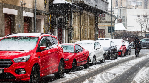 Snowing on cars in the morning, snow on street in Bucharest, Romania, 2021