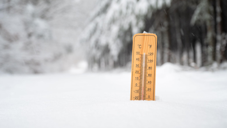 Thermometer in snow covered landscape, cold frosty weather forecast in winter, measure the temperature