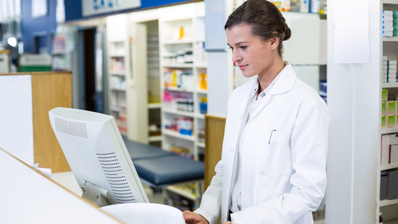 Pharmacist making prescription record through computer in pharmacy