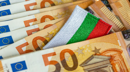 Admission of Bulgaria to the euro zone in 2026. The flag of Bulgaria sticking out from between the Euro banknotes. Financial concept.