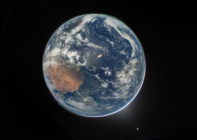 A high resolution view of Earth taken by NASA astronaut and Artemis II Commander Reid Wiseman from of the Orion spacecraft's window after completing the translunar injection burn on April 2, 2026. The image features two auroras (top right and bottom left)