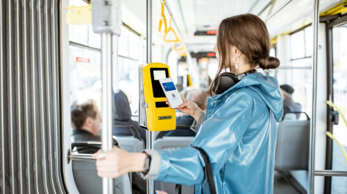 Woman paying conctactless with smartphone for the public transport in the tram