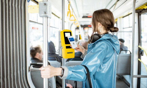 Woman paying conctactless with smartphone for the public transport in the tram