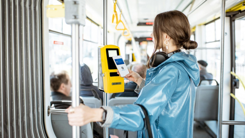 Woman paying conctactless with smartphone for the public transport in the tram