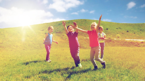 group of happy kids running outdoors