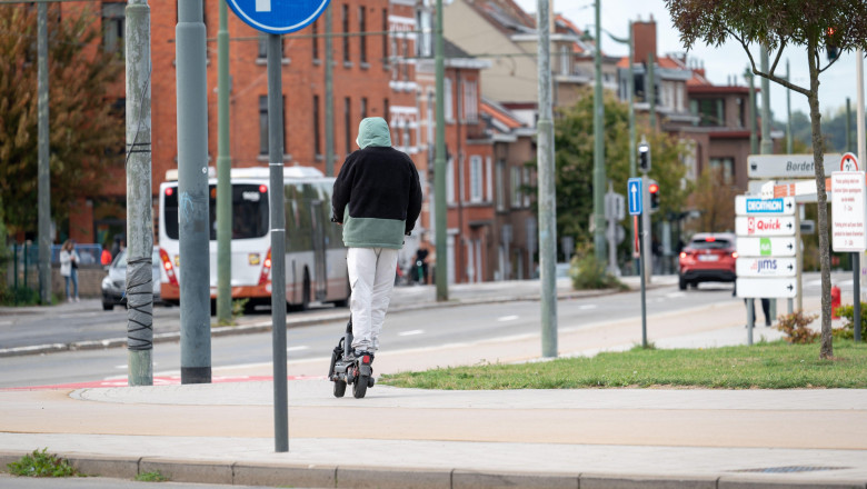 Young man with hoody on an e step scooter in Evere, Brussels, Belgium 21 SEP 2025