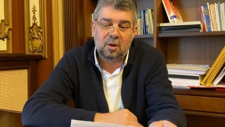 Marcel Ciolacu, citește de pe foi lângă o bibliotecă
