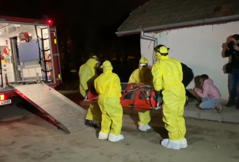 Medici scot un pacient cu izoleta din ambulanță pe timp de noapte, COVID-19, coronavirus