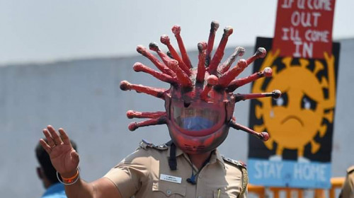 Polițist indian cu cască de coronavirus