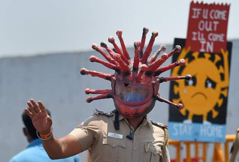 Polițist indian cu cască de coronavirus